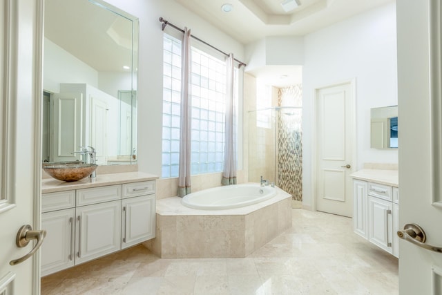 bathroom featuring vanity and tiled bath