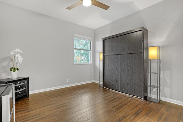 unfurnished bedroom with dark hardwood / wood-style floors, ceiling fan, and a closet