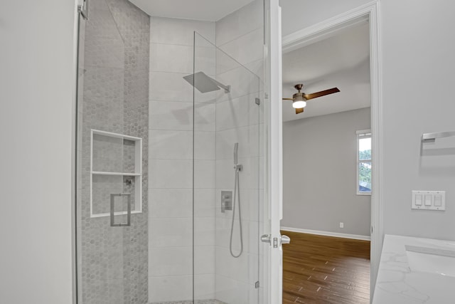 bathroom featuring hardwood / wood-style flooring, vanity, ceiling fan, and walk in shower