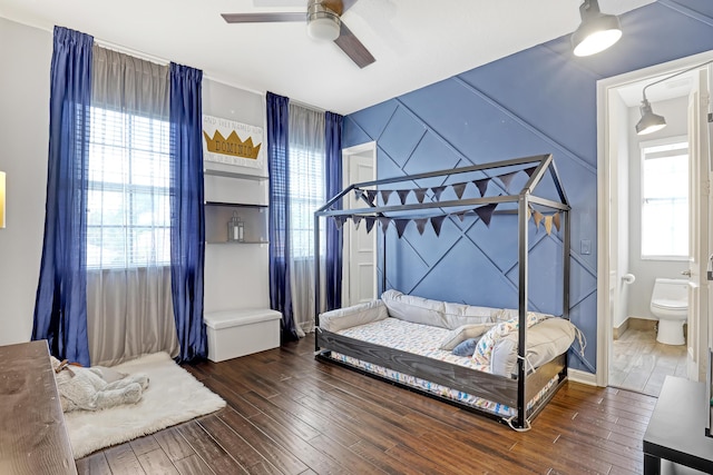 bedroom featuring ceiling fan, dark hardwood / wood-style floors, and ensuite bath