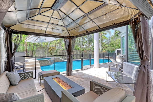 view of swimming pool with a gazebo, an in ground hot tub, a patio area, and an outdoor living space with a fire pit