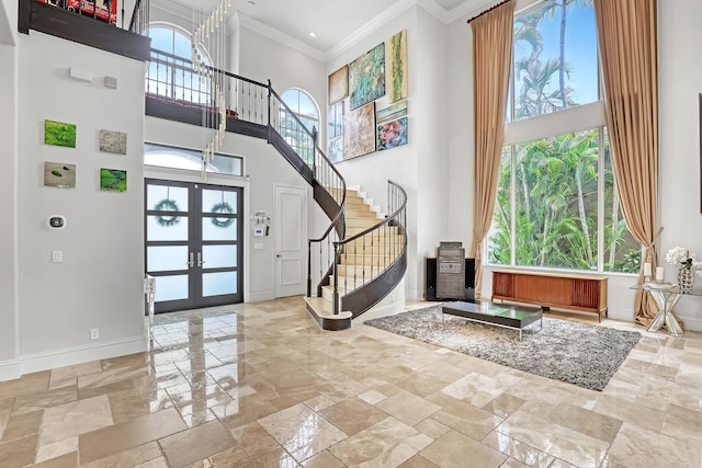 entryway featuring ornamental molding, french doors, a high ceiling, and plenty of natural light