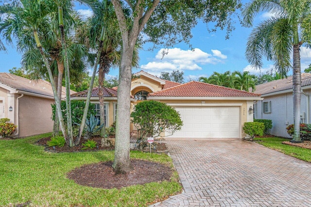 view of front facade featuring stucco siding, decorative driveway, a tile roof, a front lawn, and an attached garage