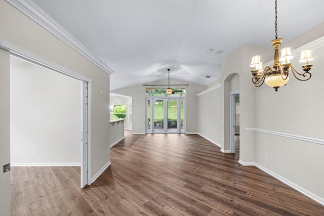 unfurnished dining area featuring arched walkways, a chandelier, vaulted ceiling, baseboards, and dark wood-type flooring