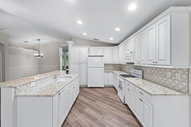 kitchen with a sink, a chandelier, light wood-style floors, white appliances, and lofted ceiling