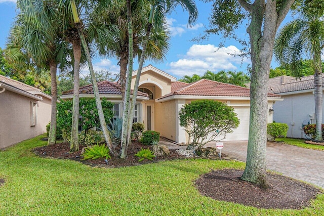 mediterranean / spanish home with stucco siding, decorative driveway, a garage, a tile roof, and a front yard