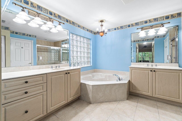 full bathroom featuring a stall shower, two vanities, a garden tub, and a sink