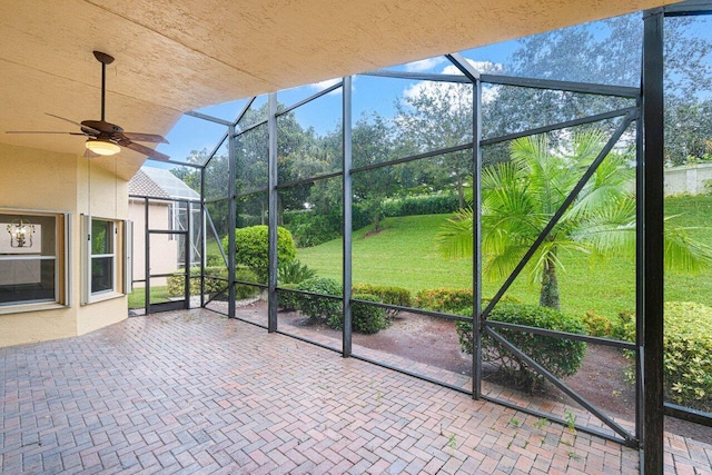 unfurnished sunroom with a ceiling fan
