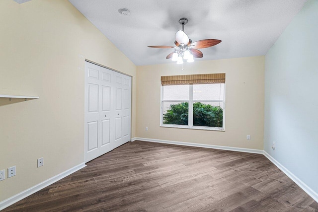 unfurnished bedroom featuring lofted ceiling, ceiling fan, a textured ceiling, hardwood / wood-style flooring, and a closet