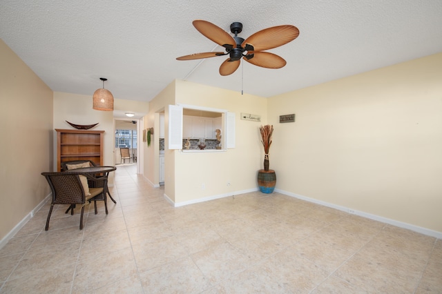 tiled spare room with ceiling fan and a textured ceiling