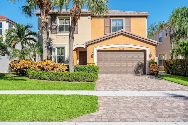 mediterranean / spanish home with a front yard and a garage