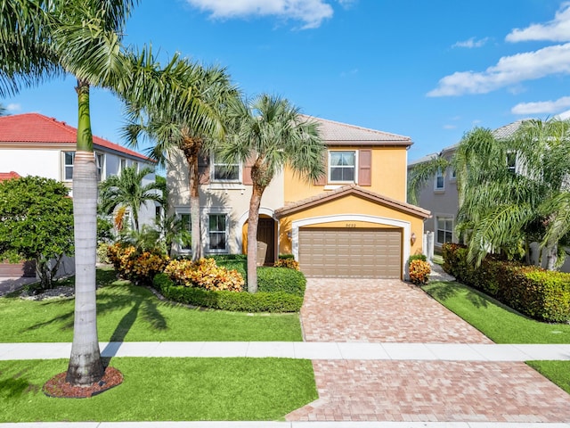 mediterranean / spanish house featuring stucco siding, a front lawn, a garage, a tile roof, and decorative driveway