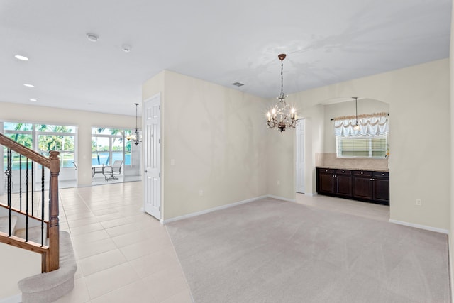 carpeted empty room featuring a chandelier