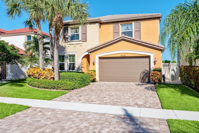 mediterranean / spanish-style home featuring a garage and a front yard