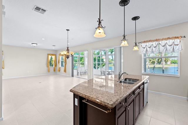 kitchen with light stone countertops, sink, stainless steel dishwasher, a notable chandelier, and pendant lighting