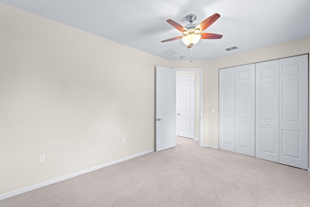 unfurnished bedroom featuring light carpet, a closet, and ceiling fan