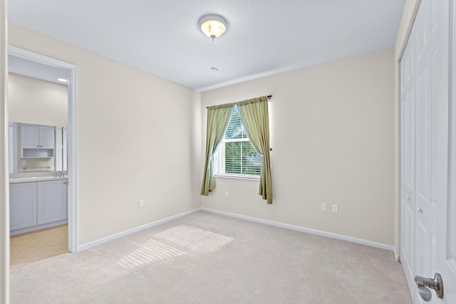 unfurnished bedroom featuring light carpet and a closet