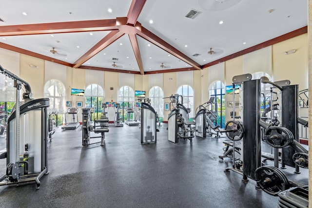 exercise room with ceiling fan and a high ceiling