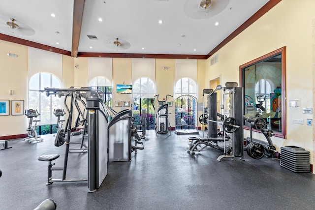 exercise room featuring ceiling fan and a towering ceiling