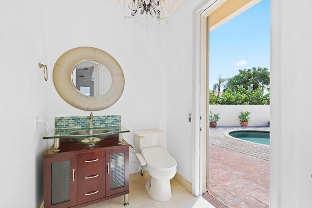 bathroom with vanity, a chandelier, and toilet