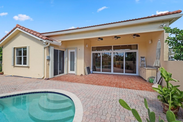 rear view of house with ceiling fan and a patio