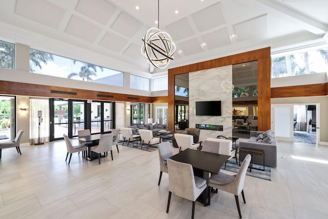 tiled dining space with french doors, coffered ceiling, an inviting chandelier, a high end fireplace, and a towering ceiling