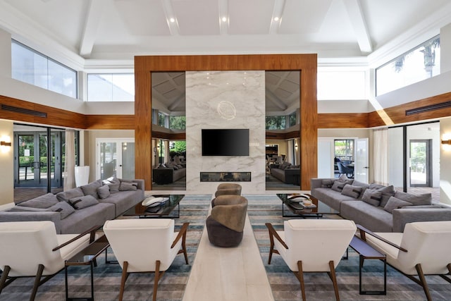 living room featuring a high ceiling, plenty of natural light, and a premium fireplace