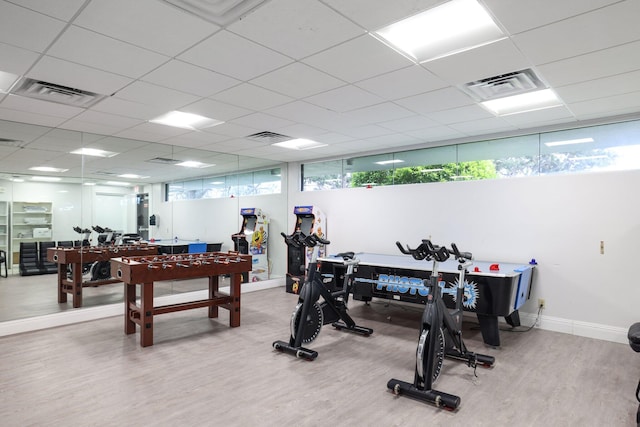 exercise room with a drop ceiling and hardwood / wood-style flooring