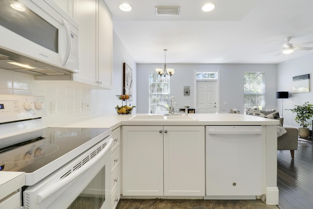 kitchen with white cabinets, white appliances, sink, and a wealth of natural light