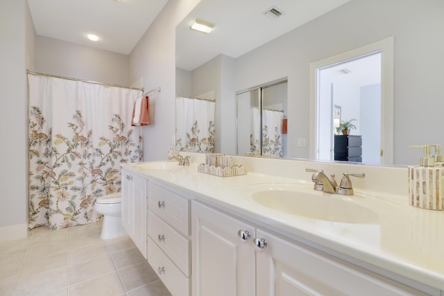 bathroom with tile patterned flooring, vanity, and toilet