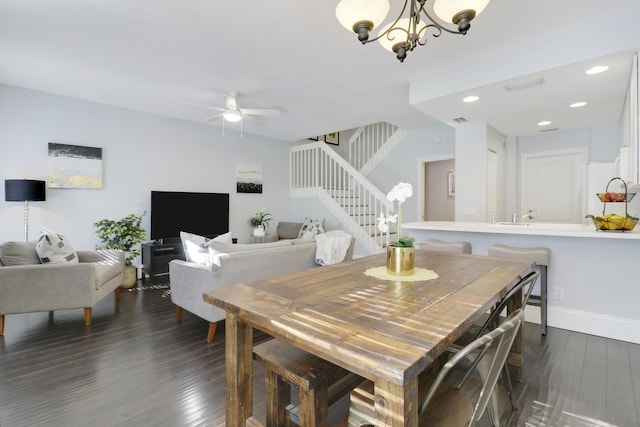 dining space featuring ceiling fan with notable chandelier and dark hardwood / wood-style floors