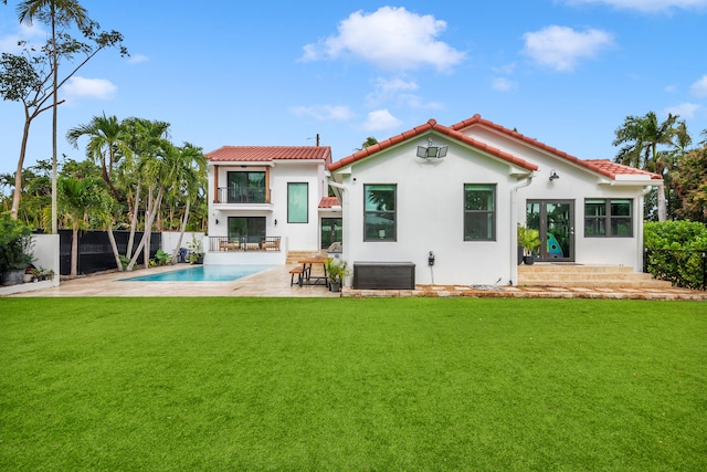 back of house featuring a yard, a patio, and a fenced in pool