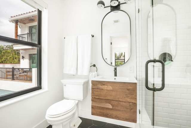 bathroom featuring vanity, an enclosed shower, toilet, and tile patterned flooring