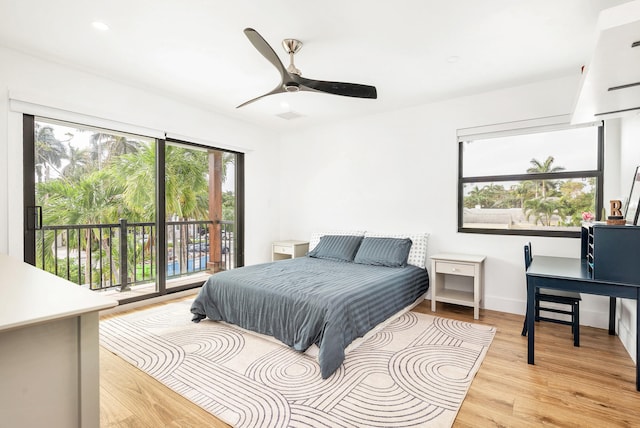 bedroom featuring access to exterior, multiple windows, light hardwood / wood-style floors, and ceiling fan