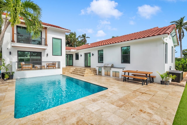 rear view of house with a patio and a balcony