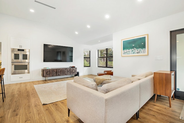 living room with lofted ceiling and light wood-type flooring