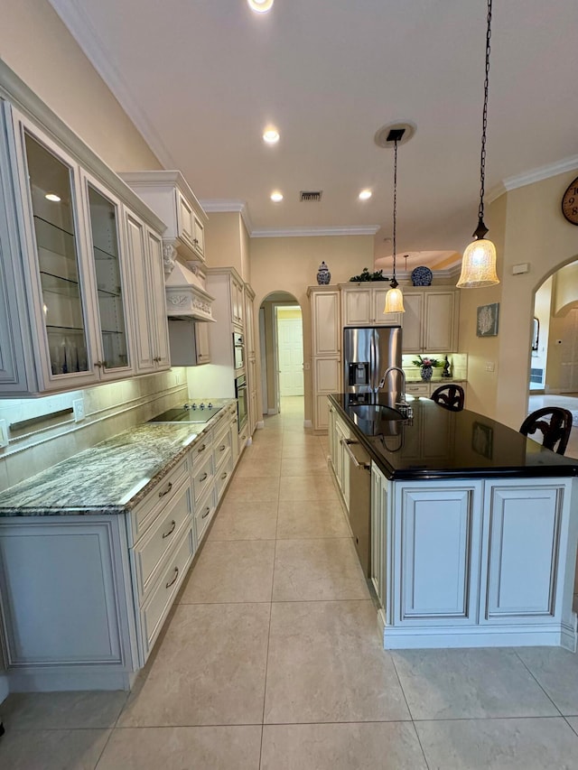 kitchen featuring appliances with stainless steel finishes, sink, an island with sink, pendant lighting, and crown molding