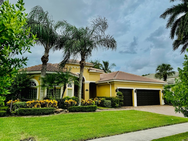 mediterranean / spanish-style home with a front yard and a garage