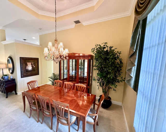 dining room featuring an inviting chandelier, ornamental molding, and a raised ceiling