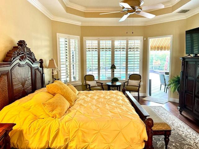 bedroom with hardwood / wood-style flooring, ornamental molding, and multiple windows