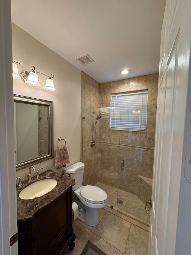 bathroom with toilet, vanity, tile patterned floors, and a shower with door