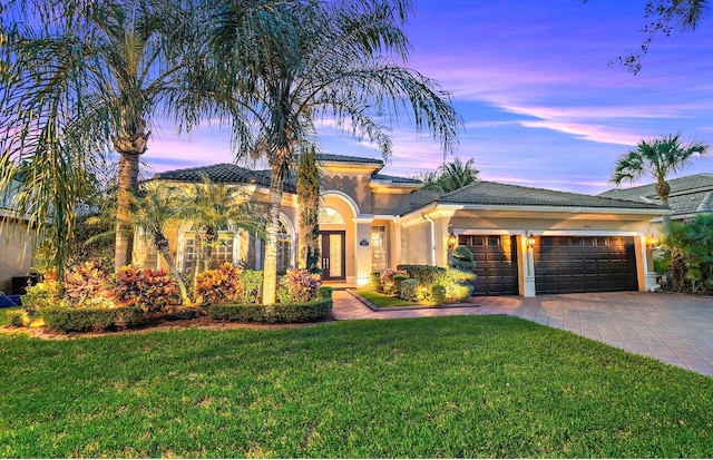 view of front of house with a garage and a lawn