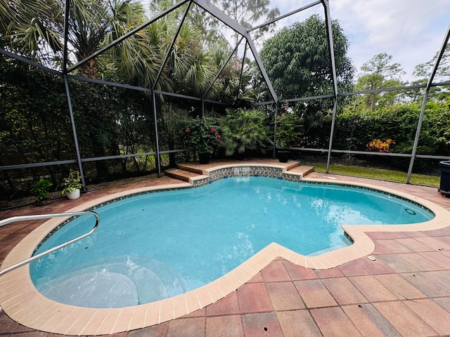 view of swimming pool with a patio area and glass enclosure