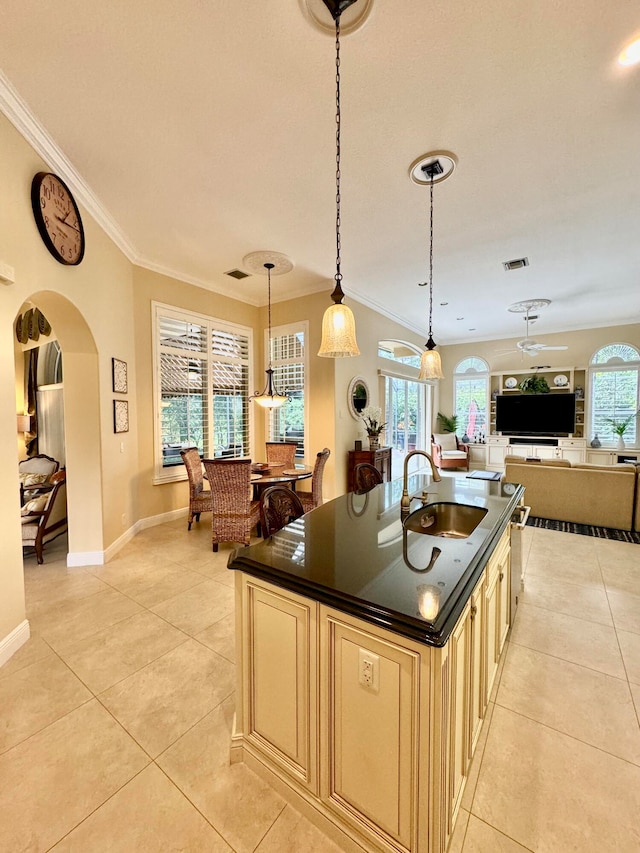 kitchen featuring ornamental molding, decorative light fixtures, and plenty of natural light