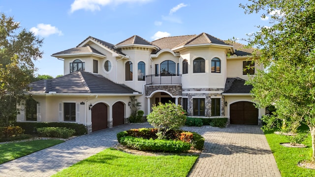 view of front of property featuring a front lawn, a garage, and a balcony