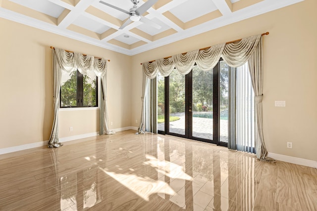 empty room featuring beamed ceiling, coffered ceiling, plenty of natural light, and ceiling fan