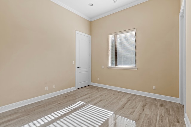 spare room with light hardwood / wood-style floors and crown molding