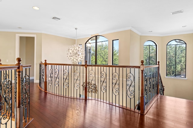 hall with ornamental molding, a chandelier, and dark wood-type flooring