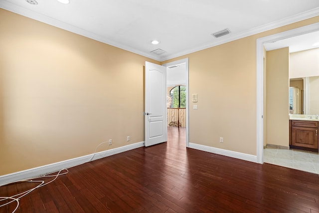 empty room featuring ornamental molding and wood-type flooring