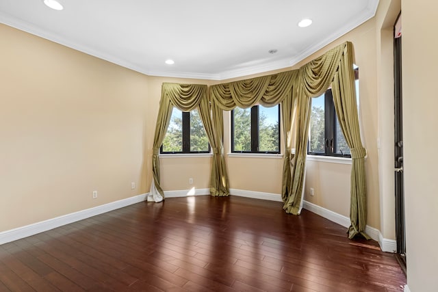 spare room with ornamental molding and dark hardwood / wood-style flooring